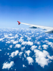 Fototapeta premium plane wing and aerial view of many fluffy clouds