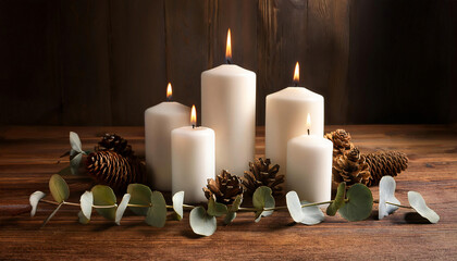 A group of white pillar candles arranged in varying heights on a rustic wooden table