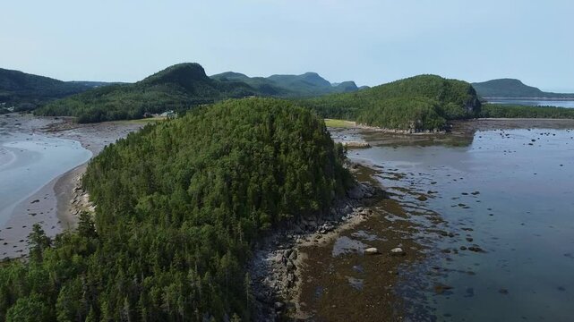 Survol en drone du Parc national du Bic, Qu&eacute;bec, Canada. Vue grandiose du Parc du Bic &agrave; mar&eacute;e basse en survolant la cime des arbres et les rochers de L'Ile-aux-Amours.