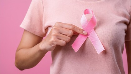 Woman hand hold Pink Ribbon Pink October Breast Cancer Awareness month close-up National cancer survivors month, Mother and World cancer day concept