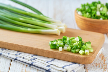 Chopped fresh green onions on a white table . Copy space for text.
