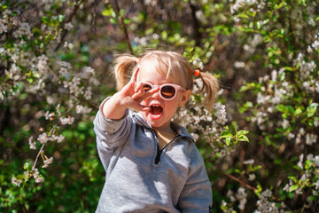 Portrait of Cute little child girl toddler in round sunglasses laughing.