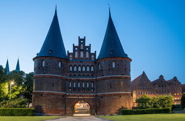 Obraz premium Holstentor und Salzspeicher in Lübeck zur blauen Stunde vor Sonnenaufgang am Morgen