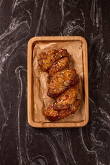 Succulent and Deliciously Glazed Asian Style Chicken Wings Served on a Wooden Platter