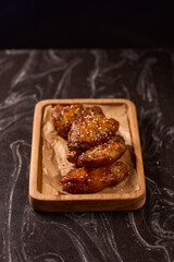 Succulent and Deliciously Glazed Asian Style Chicken Wings Served on a Wooden Platter