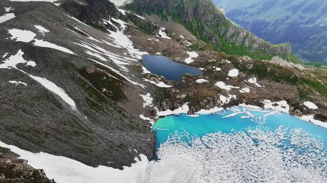 mountain landscape with lakes and high peaks, in snow in summer. drone flight in the mountains