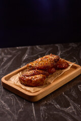 Succulent and Deliciously Glazed Asian Style Chicken Wings Served on a Wooden Platter