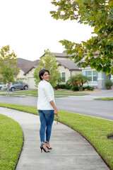 realtor woman with a key walking through a neighborhood 