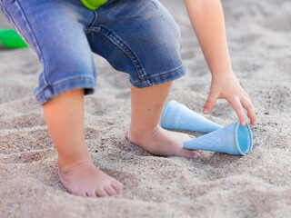 Kinder spielen mit Sandspielzeug in Nahaufnahme - nur Hände und Füße sind zu sehen