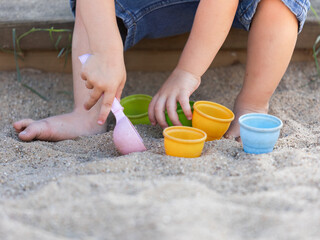 Kinder spielen mit Sandspielzeug in Nahaufnahme - nur Hände und Füße sind zu sehen