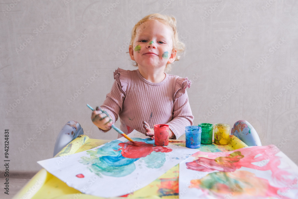 Wall mural female toddler drawing at table