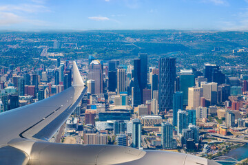 View from airplane as it approaches Calgary airport with city skyline in the background