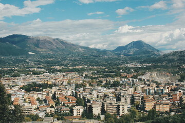 Panoramic Cityscape with Majestic Mountains Under a Clear Blue Sky