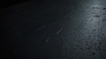 Fototapeta premium The surface displays a rich dark gray tone, featuring unique textures that create a visually appealing contrast. Soft light reflections enhance the depth and mood