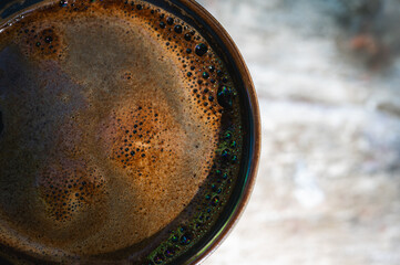  coffee background, coffee in a mug close-up with foam on a wooden table, background, morning light rays, top view, place for writing, selective focus