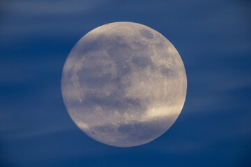 photograph of the full moon partially covered with clouds