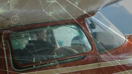 Pilot in cockpit flying small aircraft with data processing animation overlaid - Powered by Adobe