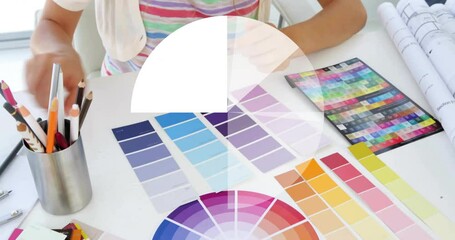 Color wheel and pie chart animation over person selecting color swatches at desk - Powered by Adobe