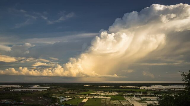 Rows of cumulonimbus formations chuffing into the upper atmosphere, glowing in the setting sun over the Tonle Sap Lake, Cambodia.