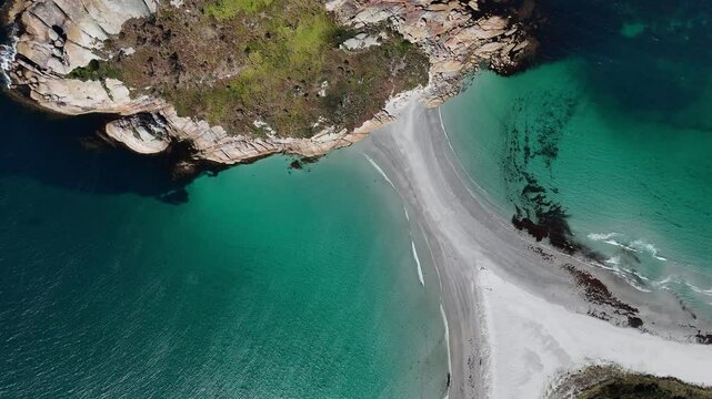 Diamond Island with idyllic rocks with sandy shoal surrounded by clear ocean water in Tasmania. Sunny day in summer season. Coral reef underwater.