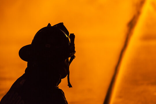 USA, Massachusetts, Cape Ann, Rockport. Fourth of July parade, firemen silhouettes by bonfire.