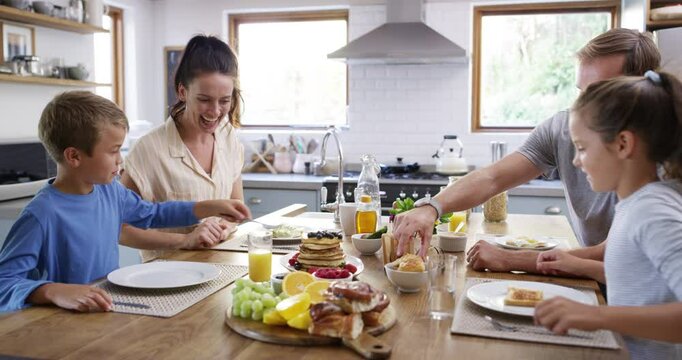 Food, happy and pancakes with family in kitchen for health, love and eating together. Smile, relax and nutrition with parents and children at dining table in home for breakfast, wellness and bonding