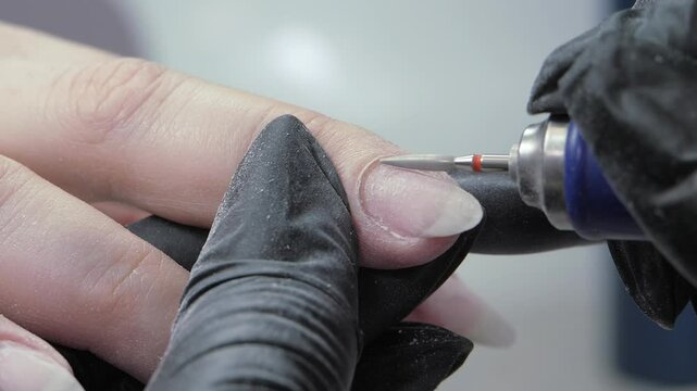 Cleaning the nail of the hand with a milling machine. Hardware combined manicure. Manicure care procedure.