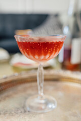 sparkling rose wine in coupe glass on silver tray