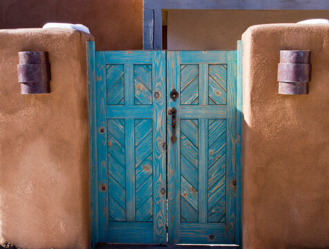 USA, New Mexico, Sante Fe. Turquoise painted wooden door with purple lights on the front of an adobe home in Sante Fe.