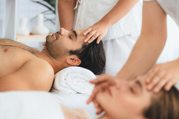 Caucasian couple enjoying relaxing anti-stress head massage and pampering facial beauty skin...