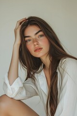 Photo of a beautiful young woman with long hair, wearing a white...