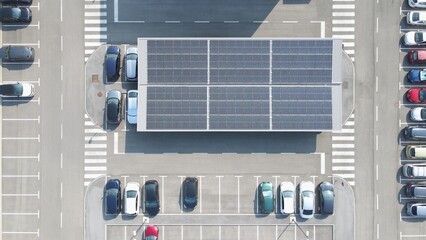 Aerial top down photovoltaic solar panel EV charging station in a parking lots with modern electric...