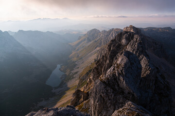 A Sunset at the Durmitor peak, Bobotom Kuk, overlooking a lake in the valley while sunrays pierce through