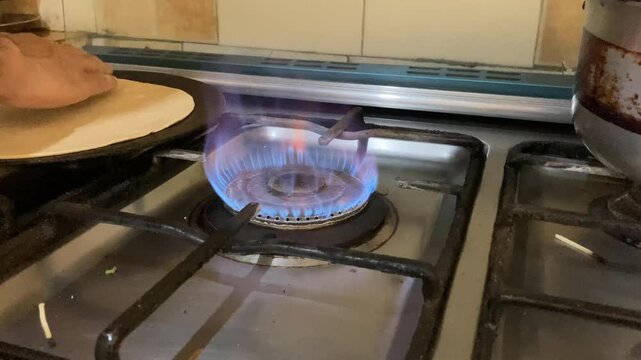 Making of Pakistani roti kinda of chappati on a gas stove. Roti is a thin bread made at home by the housewives. 