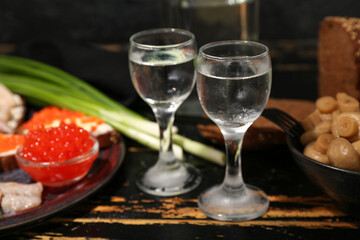 Shots with cold vodka on dark wooden background