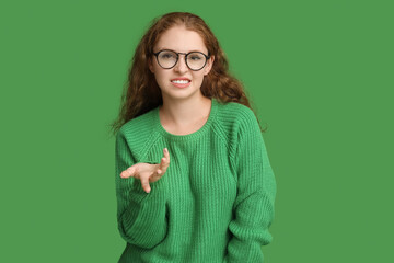 Portrait of confused young woman on green background