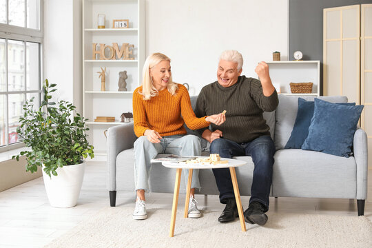 Mature couple playing jenga at home - Powered by Adobe