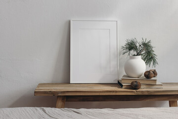 Christmas home decor. Blank greeting card, invitation stationery mockup. Old wooden console table. Modern vase, vpine tree branches. Paper christmas balls. White wall background. Scandinavian interior