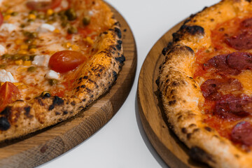Pizza set with meat and cheese. Pepperoni pizza with arugula and prosciutto. Meat pizza with cheese, cherry tomatoes and hot peppers on a white background