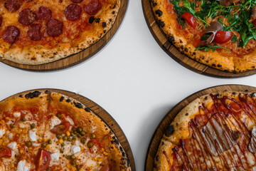 Pizza set with meat and cheese. Pepperoni pizza with arugula and prosciutto. Meat pizza with cheese, cherry tomatoes and hot peppers on a white background