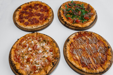 Pizza set with meat and cheese. Pepperoni pizza with arugula and prosciutto. Meat pizza with cheese, cherry tomatoes and hot peppers on a white background