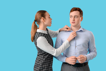 Business woman molesting her male colleague on blue background. Harassment concept