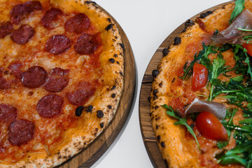 Pizza set with meat and cheese. Pepperoni pizza with arugula and prosciutto. Meat pizza with cheese, cherry tomatoes and hot peppers on a white background