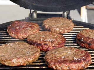 Beef burgers smoked and grilled on a barbeque over open flame