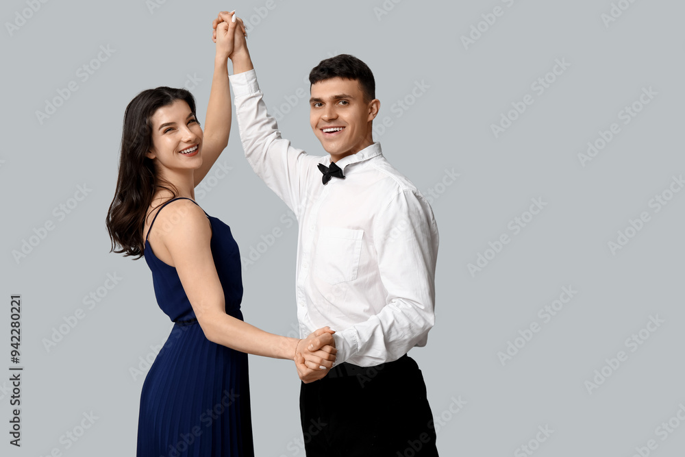 Wall mural happy young couple dancing on grey background