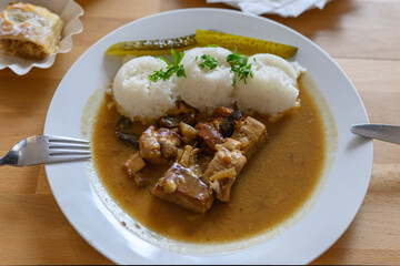 Scoops of rice with sauce and meat.
