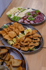 Chicken cutlets with lemon on a stainless tray.
