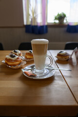 Cafe latte on table with donuts.