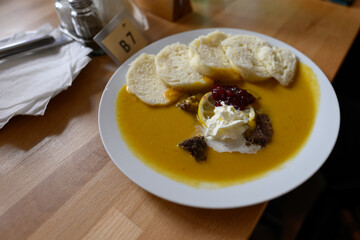 Tenderloin with dumpling and sauce on a plate.