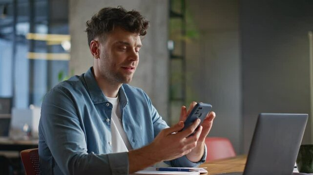Relaxed man scrolling smartphone feed enjoying break at private cabinet closeup